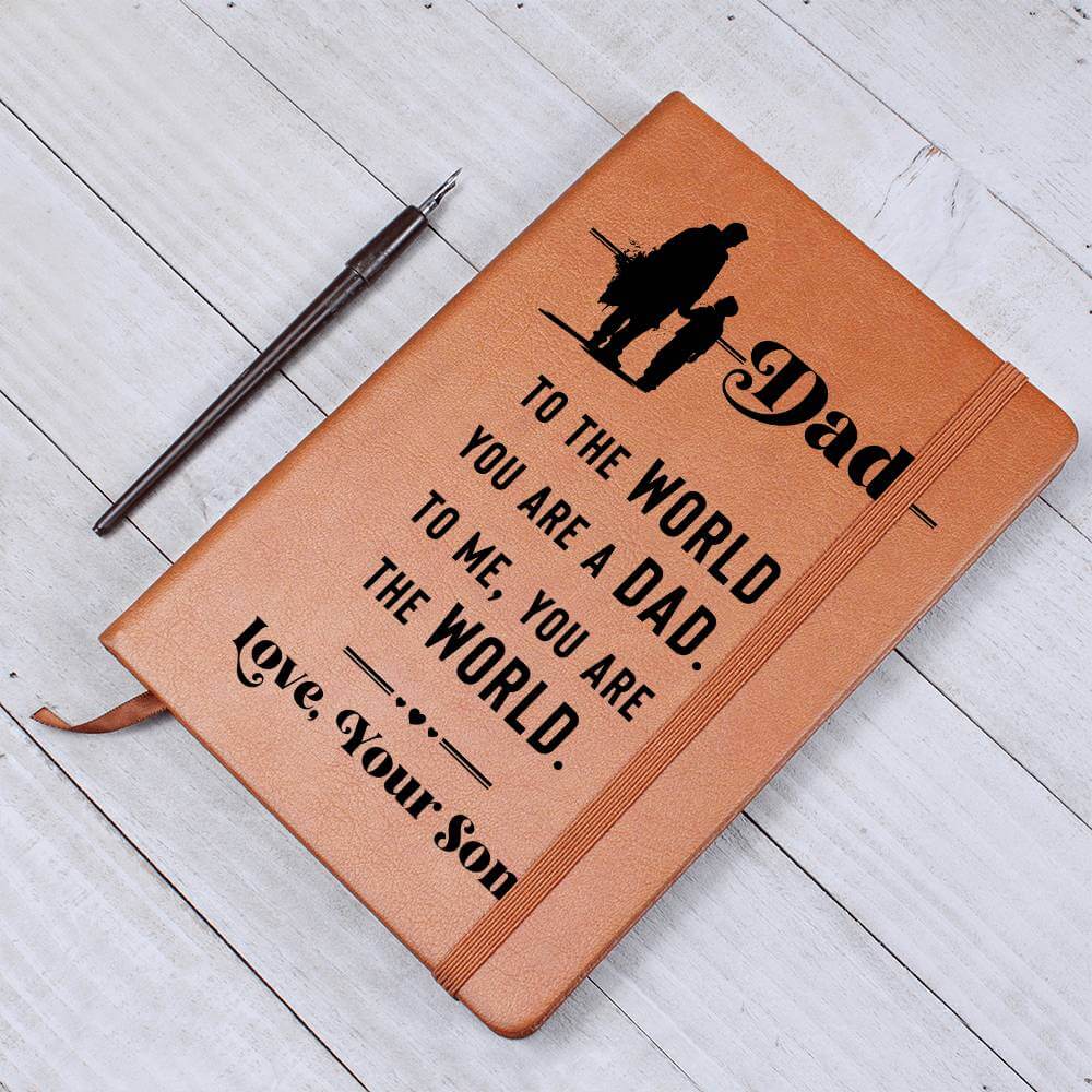 Dad, to the World you are - Graphic Leather JournalVenture beyond with the Graphic Leather Journal. Ideal for goal setting and organization, it features a bookmark and elastic closure.Moving Phrases