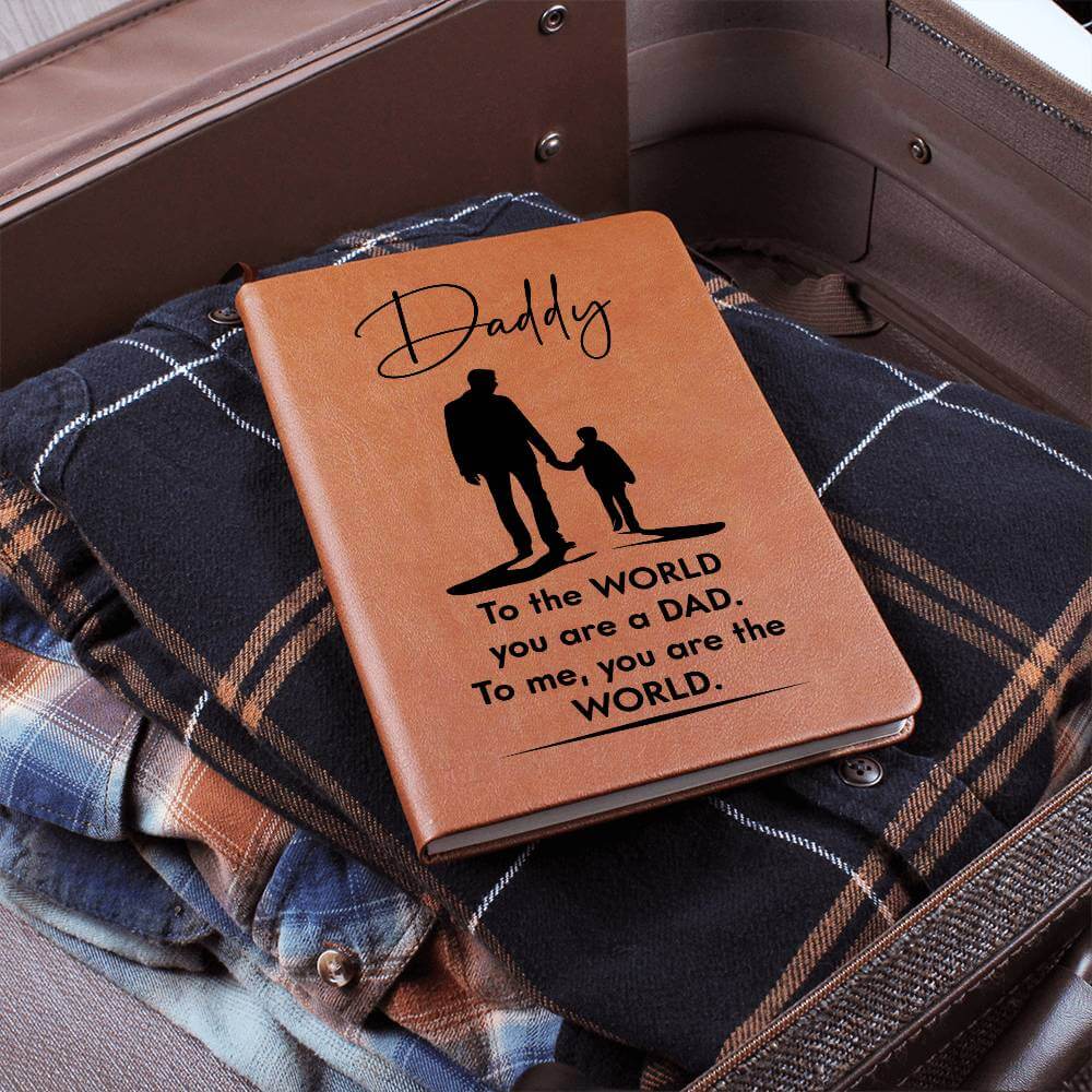 Daddy, to the World you are a Dad - Graphic Leather JournalVenture beyond with the Graphic Leather Journal. Ideal for goal setting and organization, it features a bookmark and elastic closure.Moving Phrases