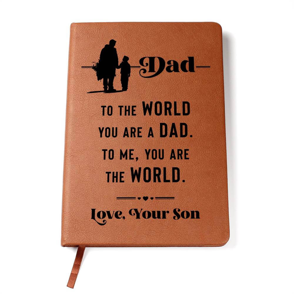 Dad, to the World you are - Graphic Leather JournalVenture beyond with the Graphic Leather Journal. Ideal for goal setting and organization, it features a bookmark and elastic closure.Moving Phrases