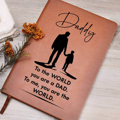 Daddy, to the World you are a Dad - Graphic Leather JournalVenture beyond with the Graphic Leather Journal. Ideal for goal setting and organization, it features a bookmark and elastic closure.Moving Phrases